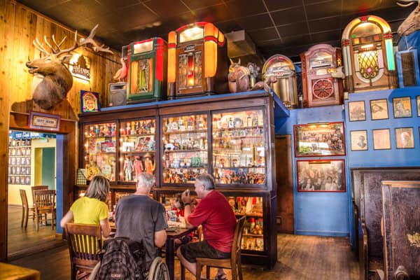 People sitting at tables in a restaurant with antiques